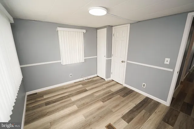 a view of a room with wooden floor and white walls