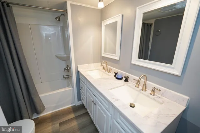 a bathroom with a sink a mirror a bathtub and shower