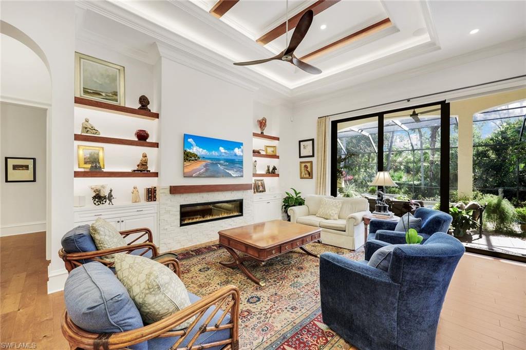 18051 Lagos Way Naples, FL 34110 - Photo 12 of 35 a living room with furniture fireplace and a large window
