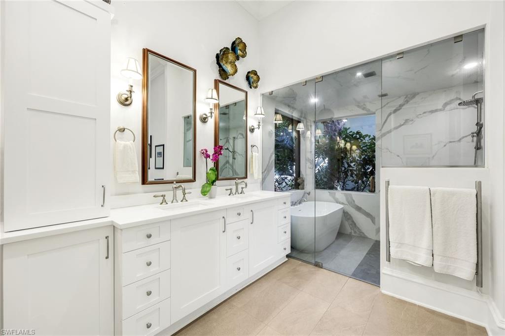 18051 Lagos Way Naples, FL 34110 - Photo 17 of 35 a bathroom with a double vanity sink mirror and toilet