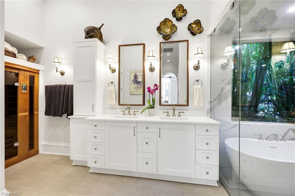 18051 Lagos Way Naples, FL 34110 - Photo 18 of 35 a bathroom with a double vanity sink mirror and bathtub
