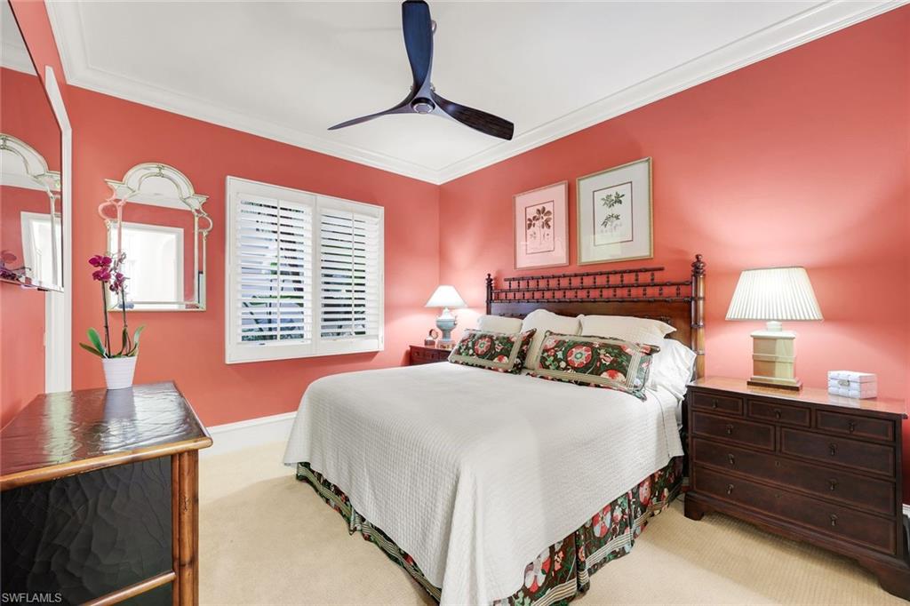 18051 Lagos Way Naples, FL 34110 - Photo 19 of 35 a bedroom with a bed and a table