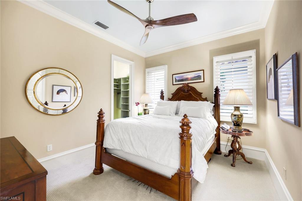 18051 Lagos Way Naples, FL 34110 - Photo 21 of 35 a bedroom with a bed and a chandelier