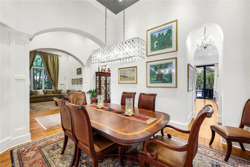 18051 Lagos Way Naples, FL 34110 - Photo 7 of 35 a dining room with furniture a rug and a chandelier
