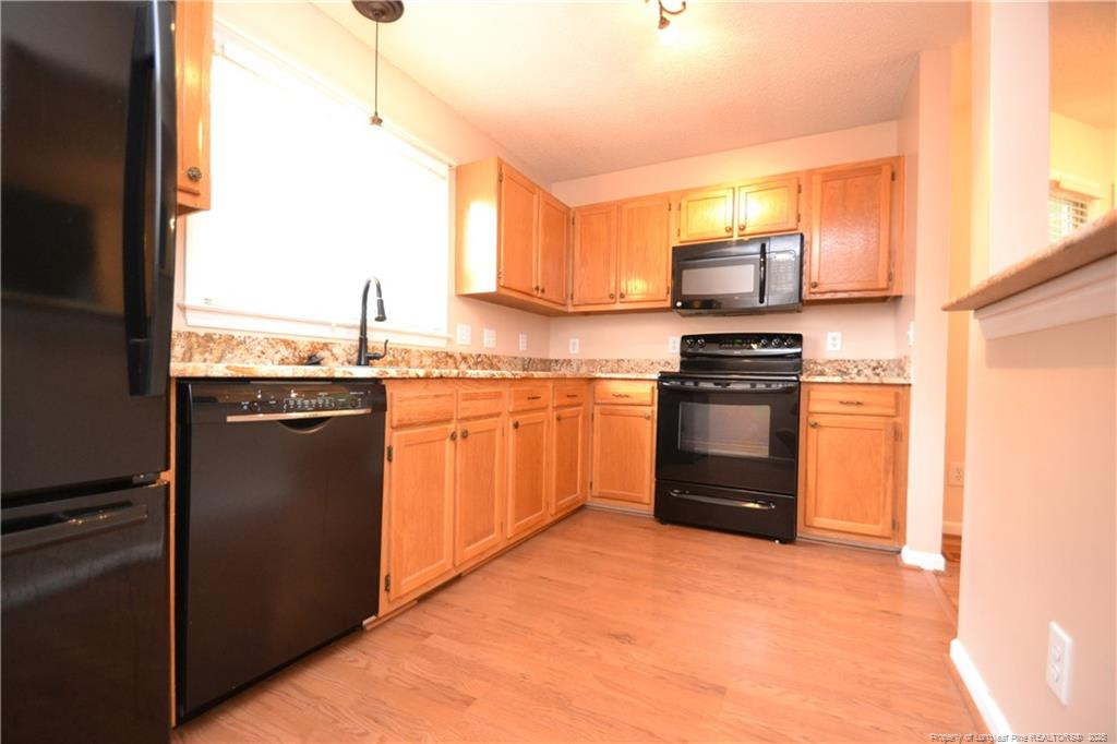 6061 Epping Forest Drive Raleigh, NC 27613 - Photo 12 of 37 a kitchen with stainless steel appliances granite countertop a stove top oven a sink and a refrigerator