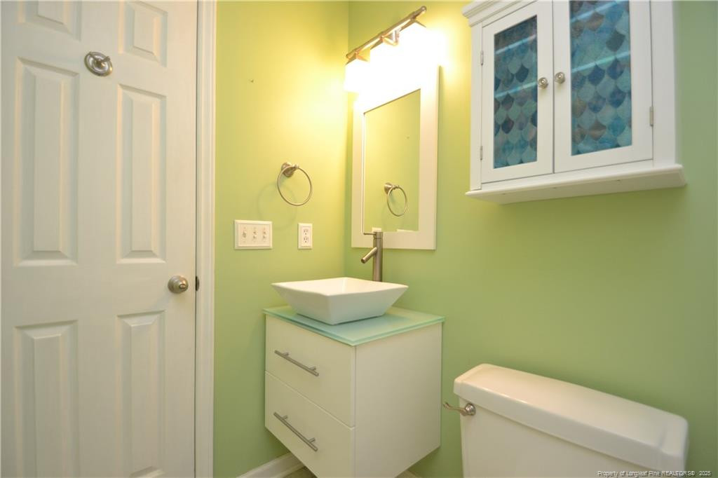 6061 Epping Forest Drive Raleigh, NC 27613 - Photo 21 of 37 a bathroom with a granite countertop toilet sink and mirror