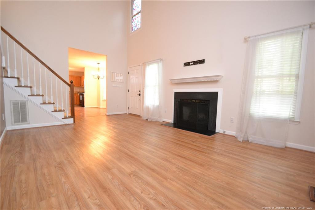 6061 Epping Forest Drive Raleigh, NC 27613 - Photo 4 of 37 a view of an empty room with wooden floor fireplace and a window