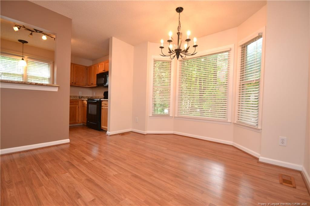 6061 Epping Forest Drive Raleigh, NC 27613 - Photo 7 of 37 a view of empty room with wooden floor and outdoor view