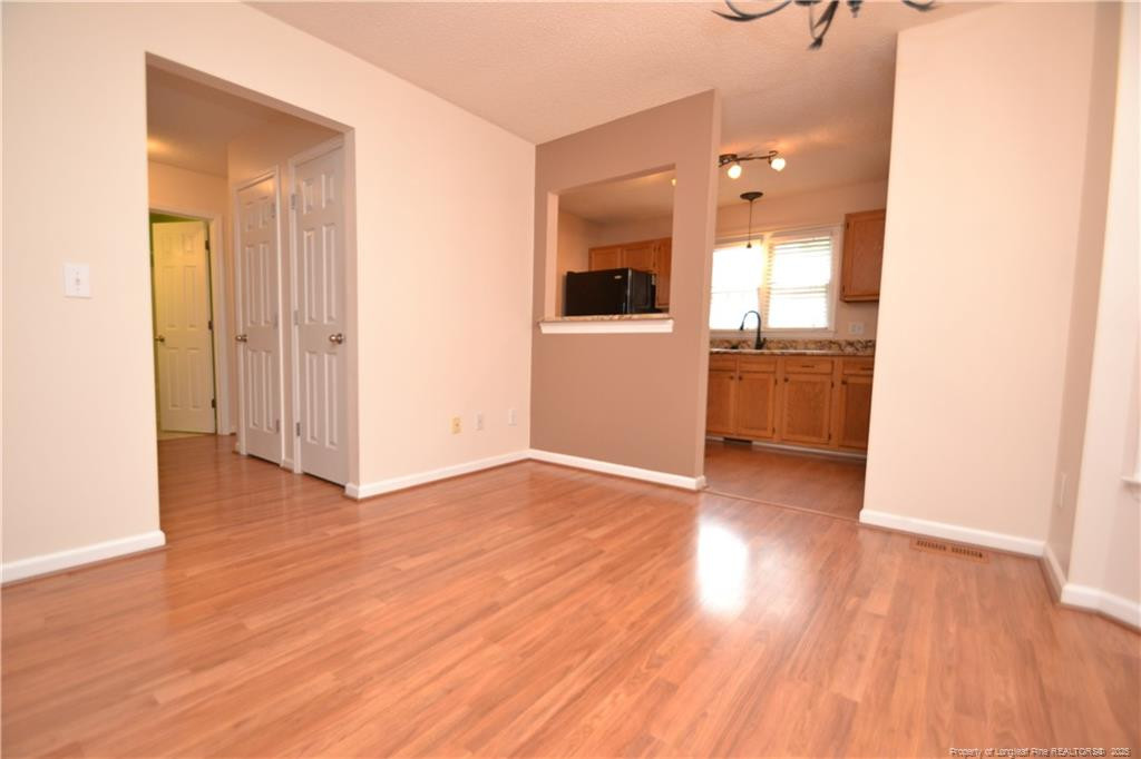 6061 Epping Forest Drive Raleigh, NC 27613 - Photo 8 of 37 a view of a hallway with wooden floor and a bathroom