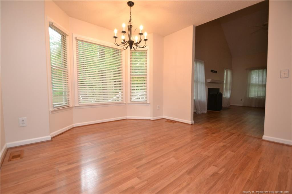 6061 Epping Forest Drive Raleigh, NC 27613 - Photo 10 of 37 a view of an empty room with window and wooden floor
