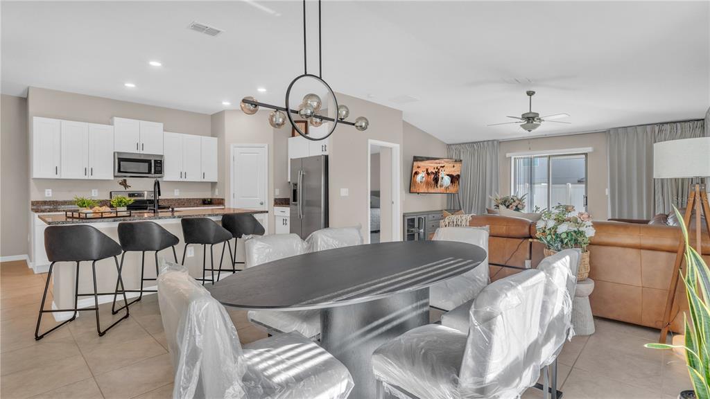 1841 Crinkle Leaf Court Ruskin, FL 33570 - Photo 12 of 35 a living room with furniture a chandelier and kitchen view