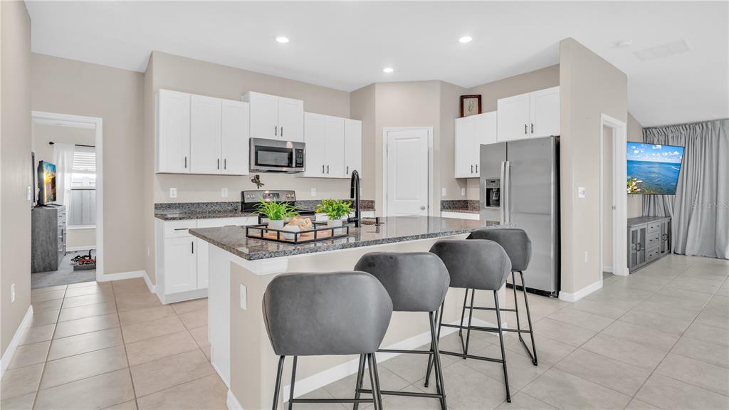1841 Crinkle Leaf Court Ruskin, FL 33570 - Photo 15 of 35 a kitchen with stainless steel appliances granite countertop a stove a refrigerator and a refrigerator