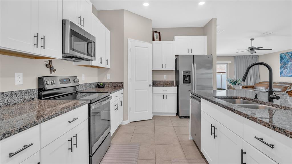 1841 Crinkle Leaf Court Ruskin, FL 33570 - Photo 16 of 35 a kitchen with stainless steel appliances granite countertop a sink stove refrigerator and cabinets