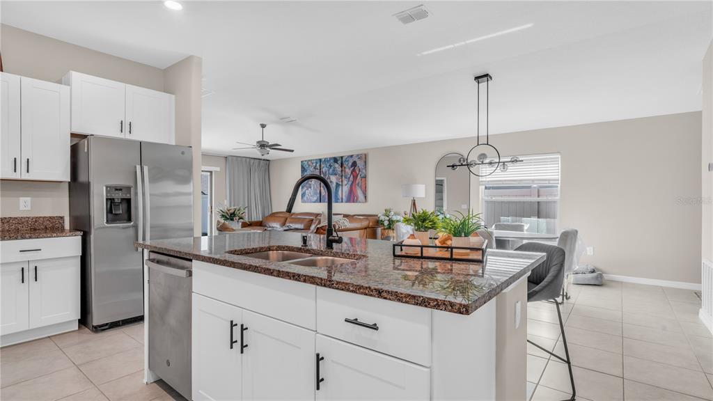 1841 Crinkle Leaf Court Ruskin, FL 33570 - Photo 17 of 35 a kitchen with stainless steel appliances kitchen island granite countertop a sink refrigerator and cabinets