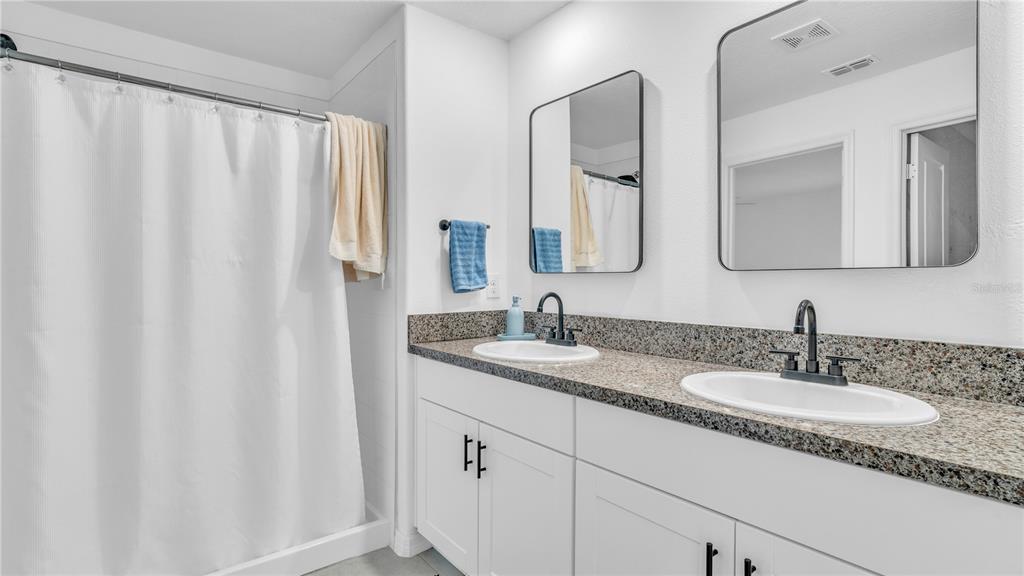 1841 Crinkle Leaf Court Ruskin, FL 33570 - Photo 23 of 35 a bathroom with a double vanity sink and mirror