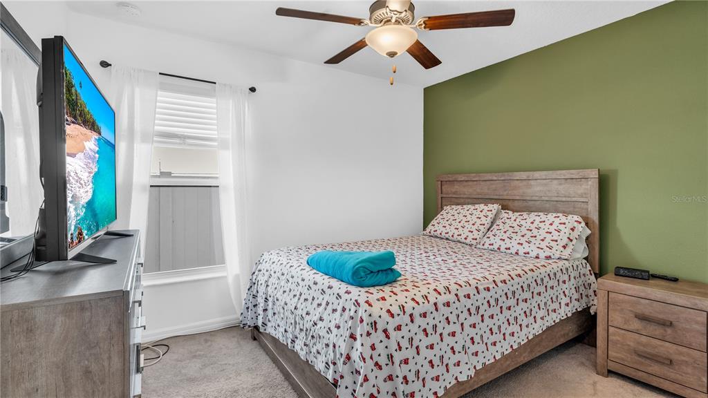 1841 Crinkle Leaf Court Ruskin, FL 33570 - Photo 27 of 35 a bedroom with a bed and a flat screen tv