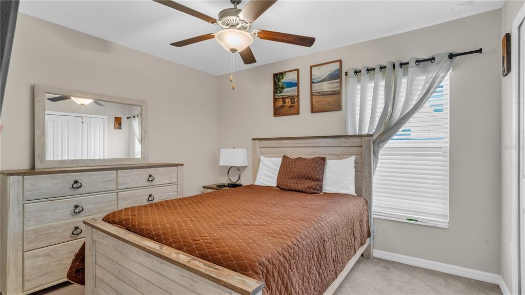 1841 Crinkle Leaf Court Ruskin, FL 33570 - Photo 28 of 35 a bedroom with a large bed and a chandelier