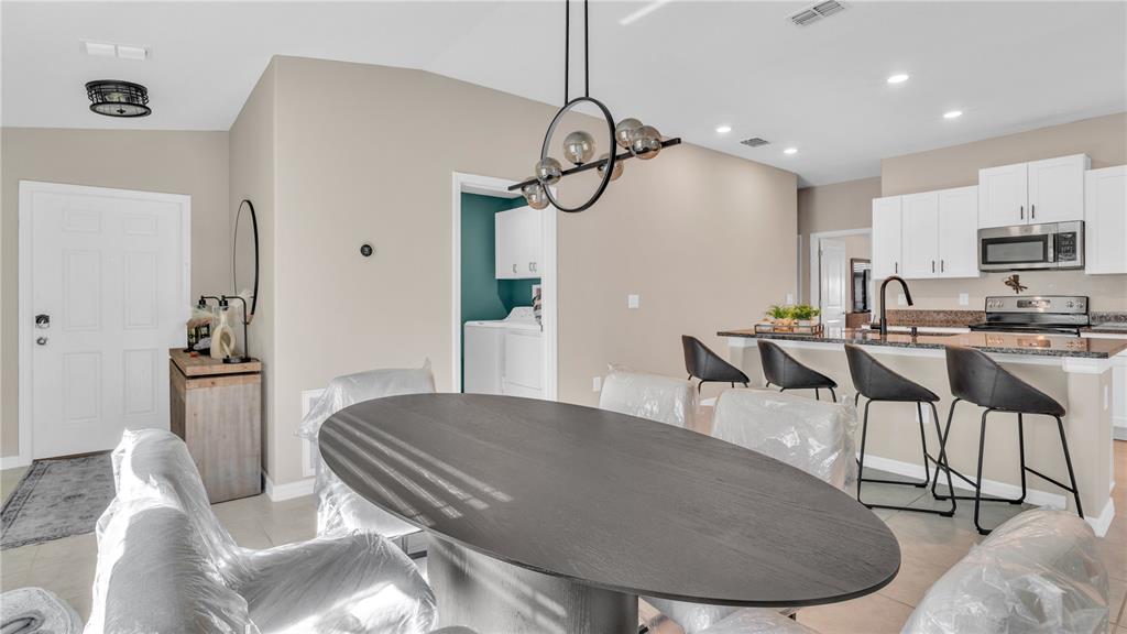 1841 Crinkle Leaf Court Ruskin, FL 33570 - Photo 10 of 35 a living room with stainless steel appliances furniture a rug and a chandelier