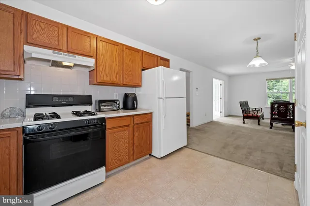 a kitchen with a stove a sink and a refrigerator