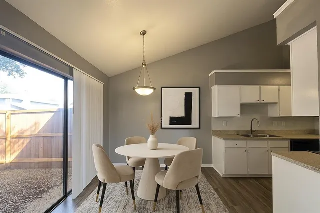 a kitchen with a table chairs sink and cabinets