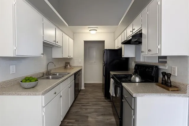 a kitchen with a sink a stove and cabinets