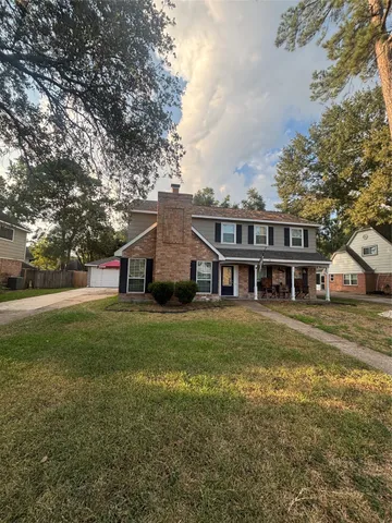 a view of a big house with a big yard and large trees