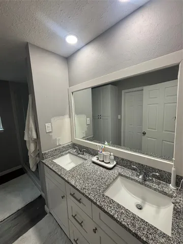 a bathroom with a granite countertop sink and a mirror
