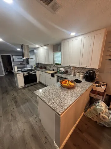 a kitchen with sink stove and cabinets