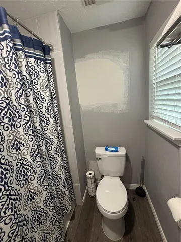 a white toilet sitting next to a small window
