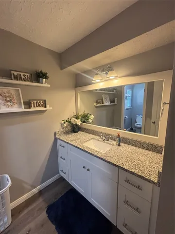 a bathroom with a granite countertop sink and a mirror