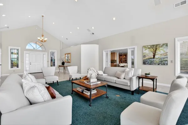 a kitchen with kitchen island granite countertop lots of white cabinets and stainless steel appliances