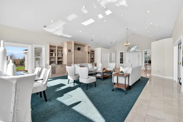 a living room with stainless steel appliances furniture a refrigerator and a kitchen island