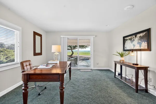 a living room with furniture a piano and a window