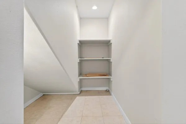 a view of a white house with a yard and potted plants