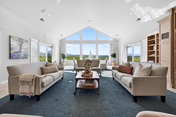 a living room with furniture and kitchen view with wooden floor