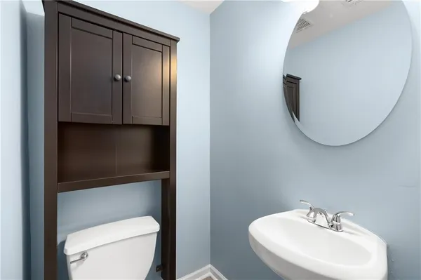 a bathroom with a toilet a sink and mirror