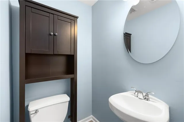 a bathroom with a toilet a sink and mirror