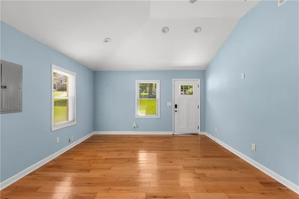 a view of empty room with window and wooden floor