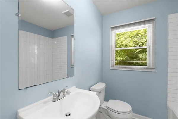 a bathroom with a sink a toilet and a window
