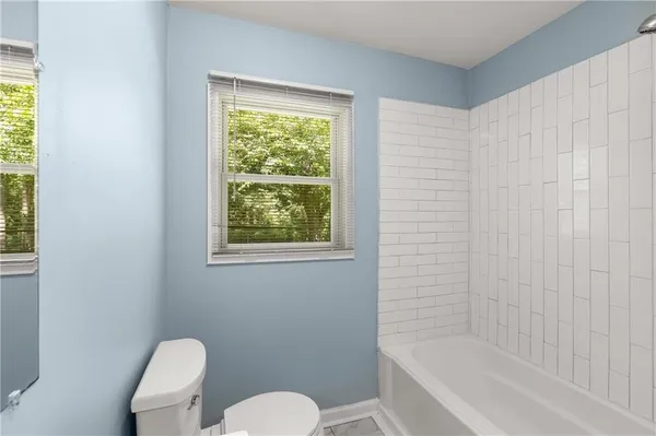 a white toilet sitting next to a bath tub