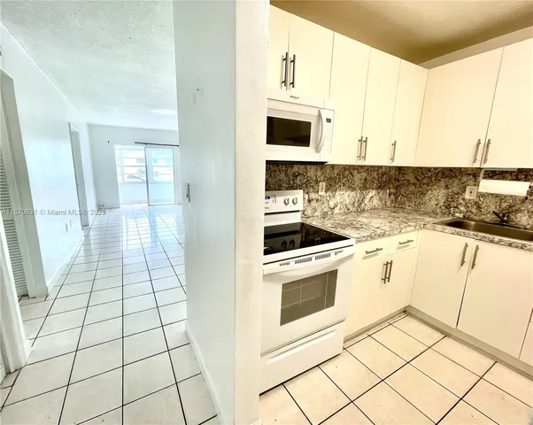 a kitchen with a sink a stove and cabinets