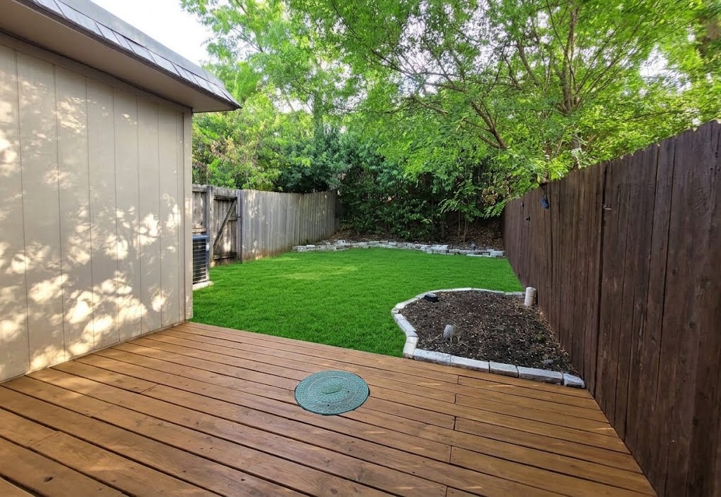 703 Castle Ridge Road, Unit B Austin, TX 78746 - Photo 16 of 18 A spacious wooden deck overlooks a grassy backyard enclosed by wooden fencing.