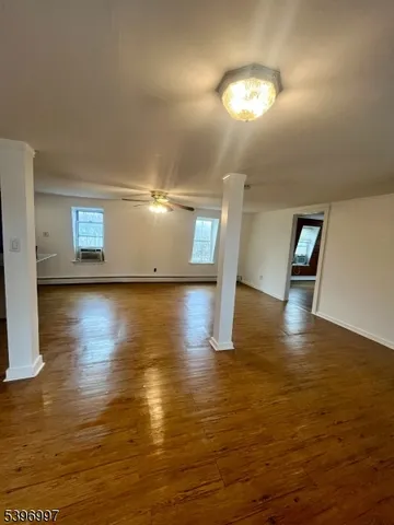 a view of empty room with wooden floor