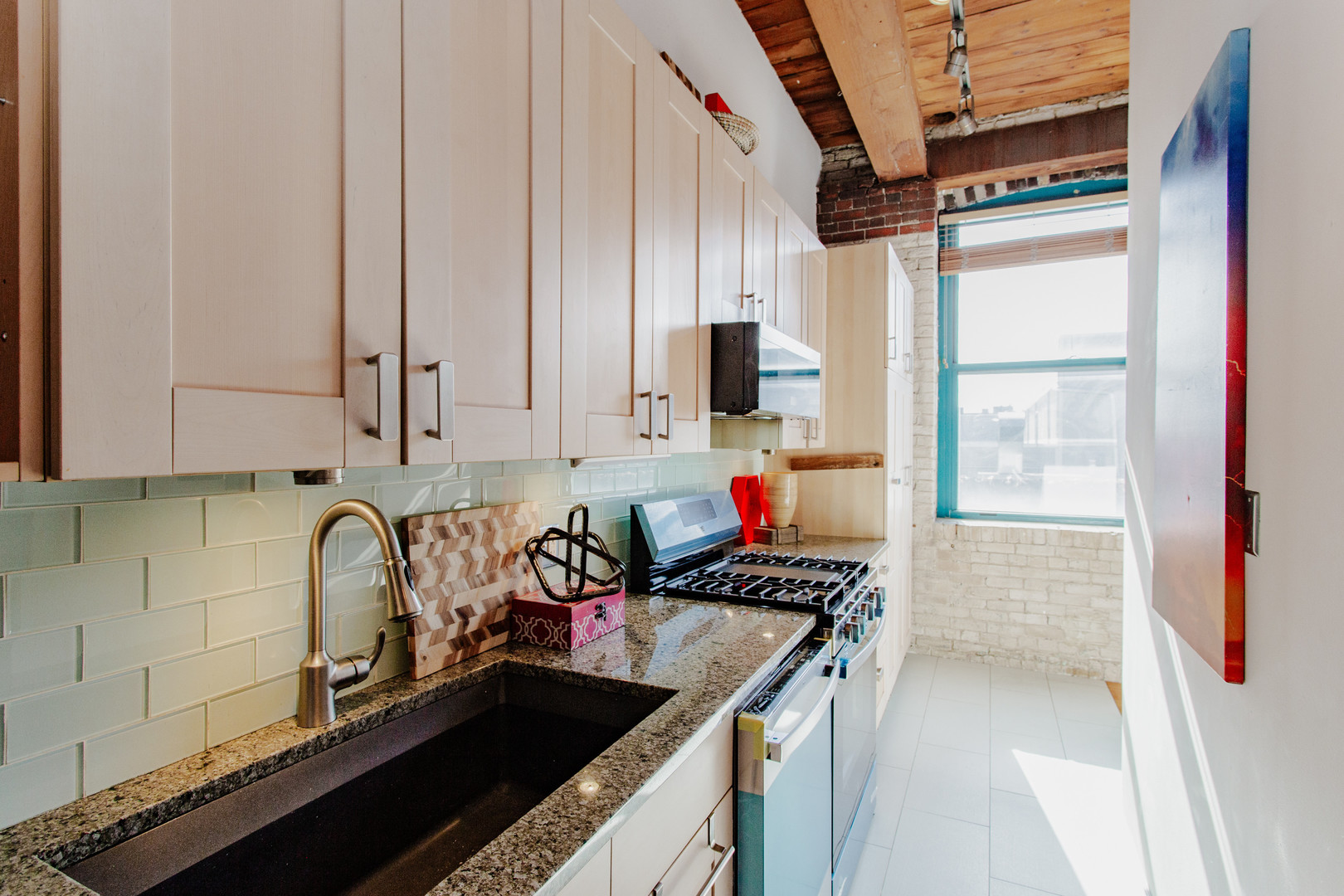 4745 North Ravenswood Avenue, Unit 210 Chicago, IL 60640 - Photo 11 of 23 a kitchen with stainless steel appliances granite countertop a sink stove and cabinets