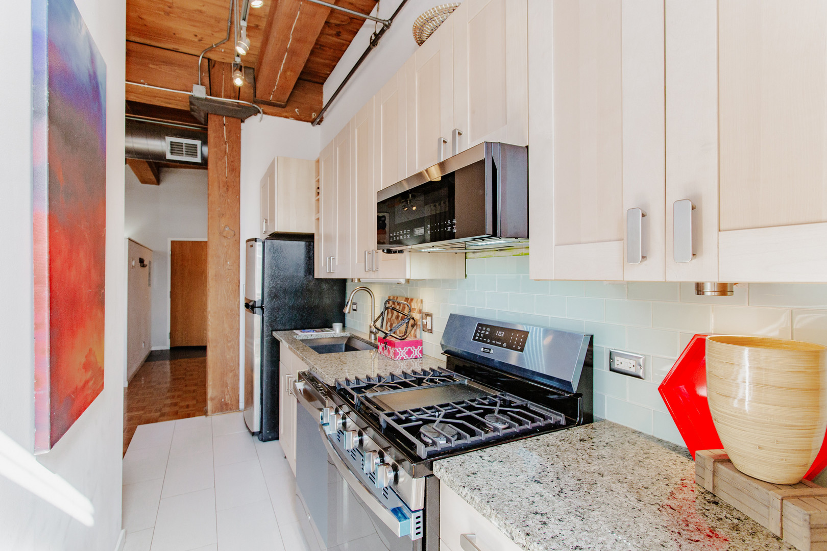 4745 North Ravenswood Avenue, Unit 210 Chicago, IL 60640 - Photo 10 of 23 a kitchen with stainless steel appliances granite countertop a stove and a refrigerator