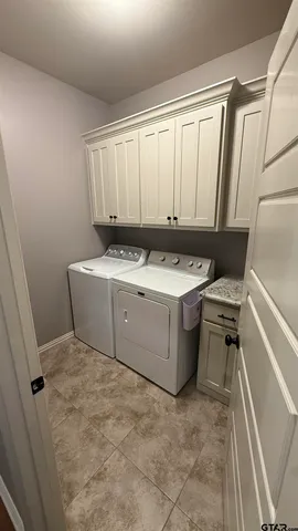 a utility room with a washer dryer and a wooden floor