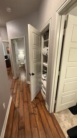 a view of a hallway with wooden floor and staircase