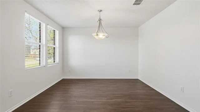 a view of a room with wooden floor and white walls