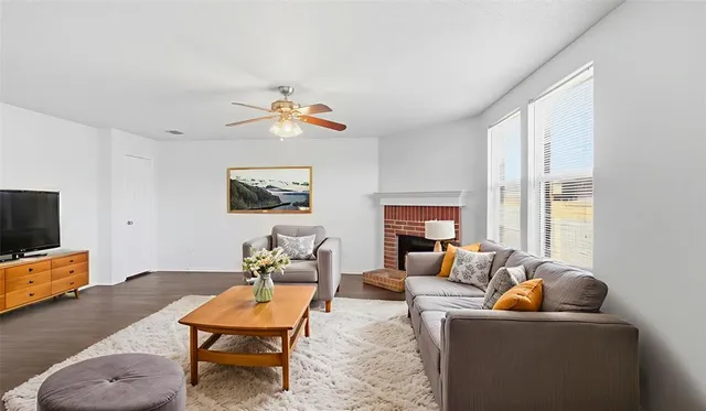 a living room with furniture a flat screen tv and a large window