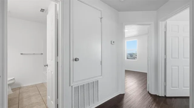 a view of a hallway with wooden floor